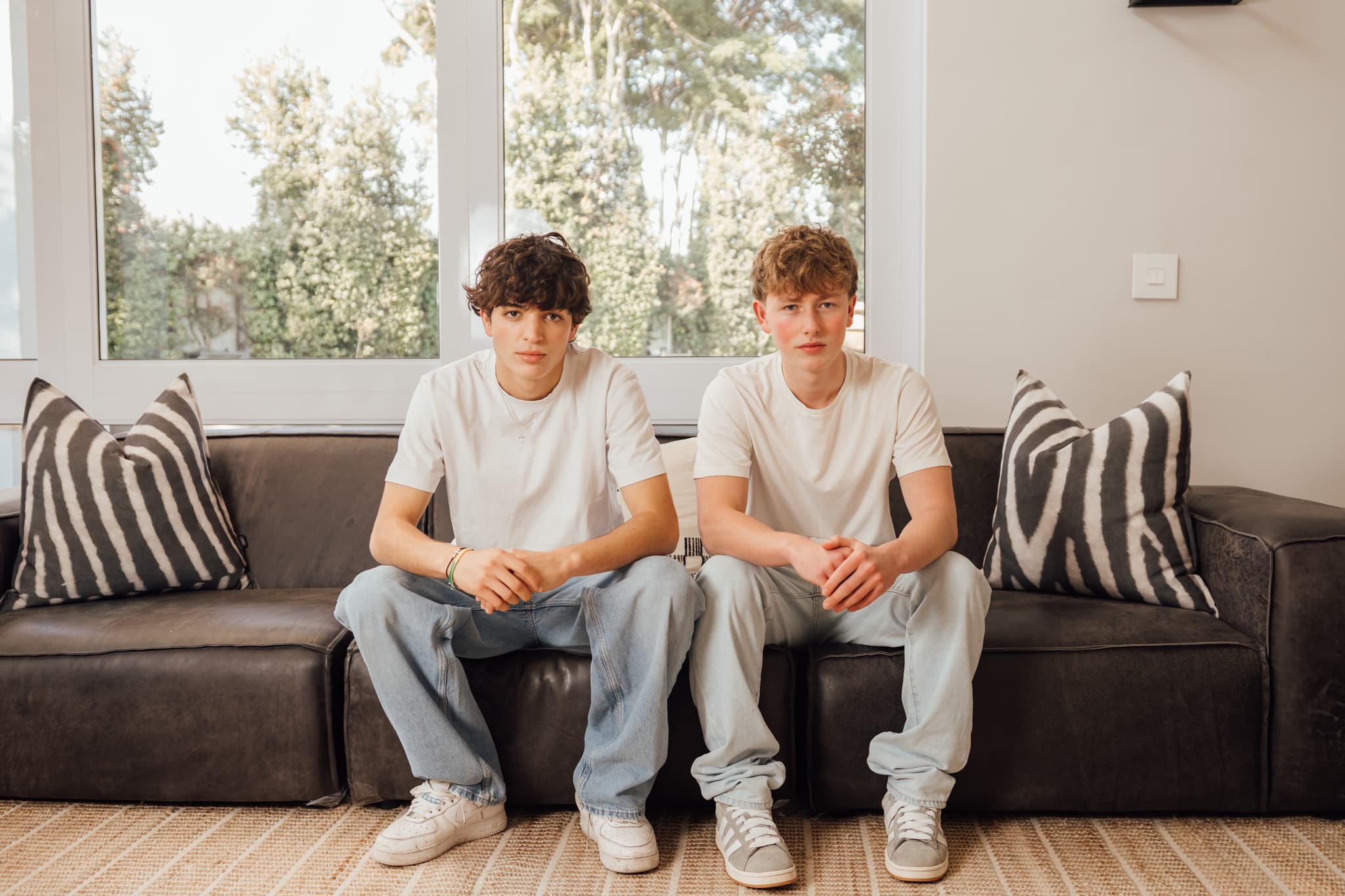 Sean and Antimo sitting side by side on a leather sofa